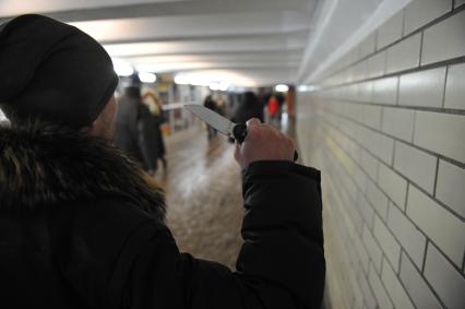 Мужчина с ножом в руках в переходе метро.