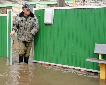 Весенним паводком затопило деревню в Самарской области. На снимке: Мужчина выходит из калитки на затопленную улицу.