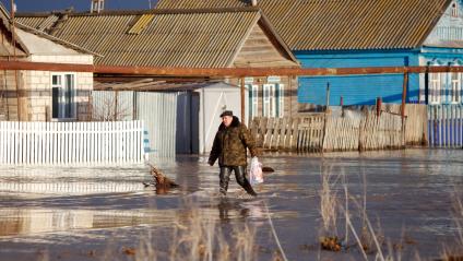 Весенним паводком затопило деревню в Самарской области. На снимке: Мужчина идет по затопленной деревенской улице.