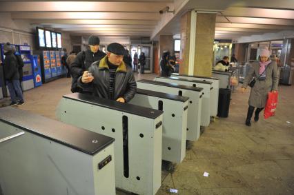 Московский метрополитен. Станция `Дмитровская`. На снимке: мужчина проходит через турникет.