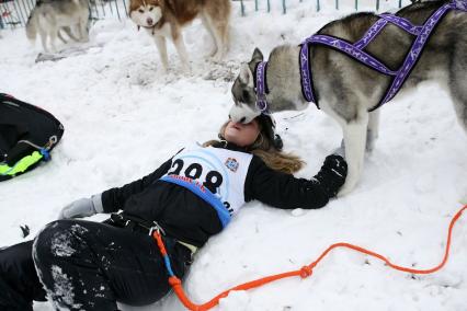В Самаре проходят соревнования заезды на собачьих упряжках. На снимке: финиш участницы заезда. Девушка лежит на снегу, собака лижет ей лицо.