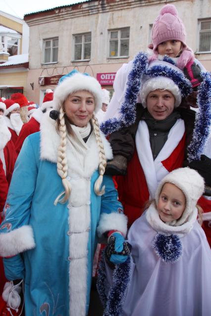 В Рыбинске тысяча Дедов Морозов прошли парадом по центральной улице города. На снимке: Семья в новогодних костюмах.