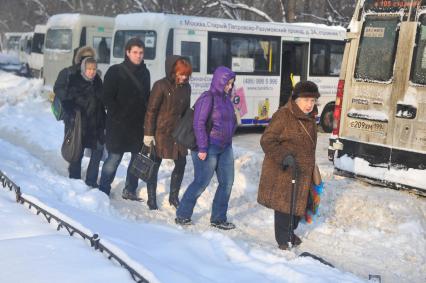 Зима в городе. На снимке: прохожие на заснеженной улице.