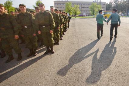 Два офицера проходят мимо строя новобранцев.