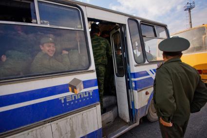 Призывники смотрят из окна автобуса.