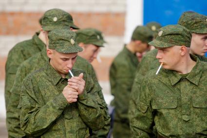 Призывники курят сигареты перед отправкой в войска.