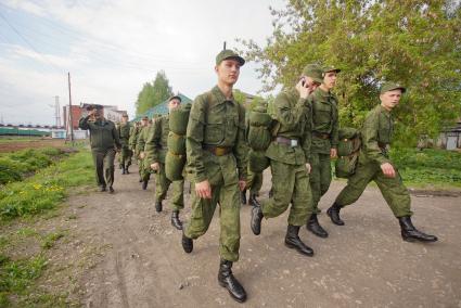 Строй солдат идет по проселочной дороге.