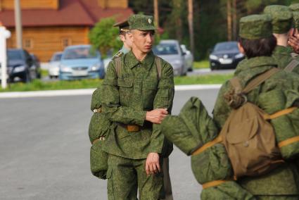 Призывник стоит на плацу у строя новобранцев.