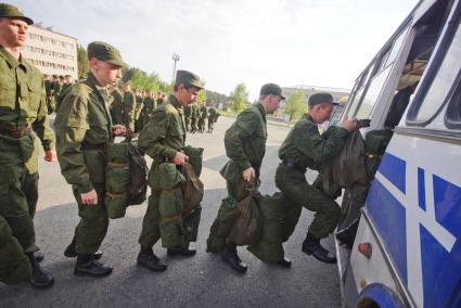 Новобранцы садятся в автобус для отправки на постоянное место службы.