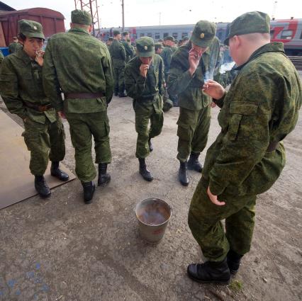 Солдаты докуривают сигареты перед отправкой в войска.