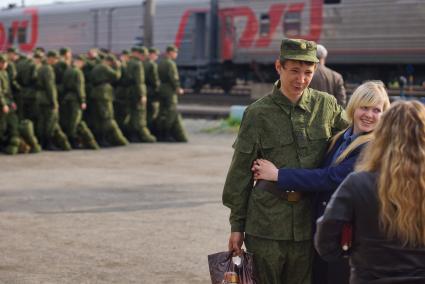 Призывник прощается с девушкой перед отправкой на службу.