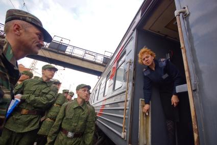 Проводница встречает колонну солдат.