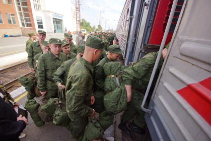 Солдаты поднимаются в вагон поезда.