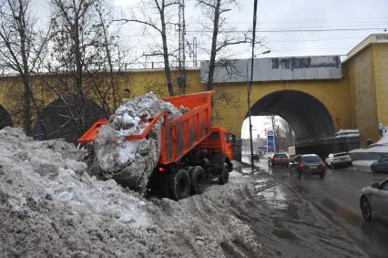 КАМАЗ отгружает снег.