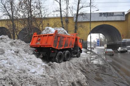 КАМАЗ отгружает снег.