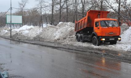 КАМАЗ отгружает снег.