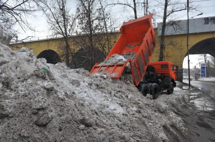 КАМАЗ отгружает снег.