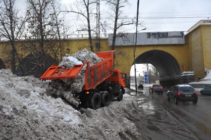 КАМАЗ отгружает снег.