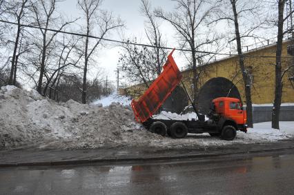 КАМАЗ отгружает снег.