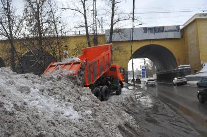 КАМАЗ отгружает снег.