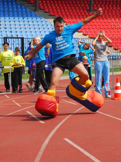 На спортивном празднике в Туле, мужчина бежит в огромных ботинках.
