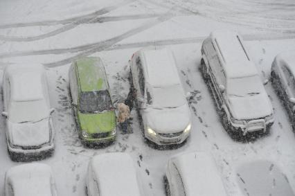 Снегопад. На снимке: автомобили в снегу.