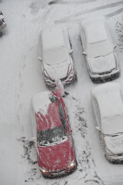 Снегопад. На снимке: автомобили в снегу.