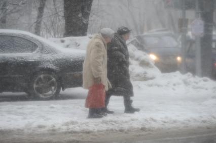 Снегопад. На снимке: две пожилые женщины.