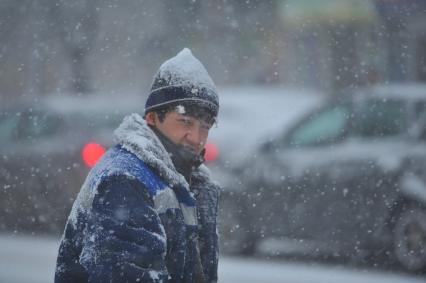 Снегопад в городе. На снимке: гастарбайтер.