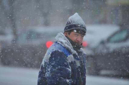 Снегопад в городе. На снимке: гастарбайтер.