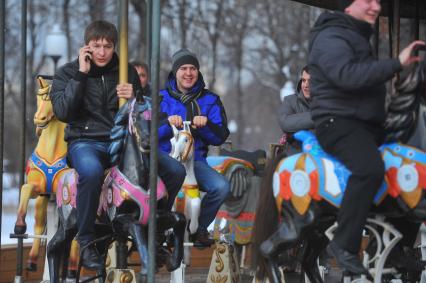 В ЦПКиО им.Горького на карусели катается компания парней.