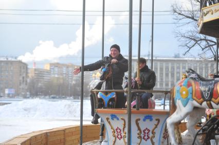 В ЦПКиО им.Горького на карусели катается компания парней.