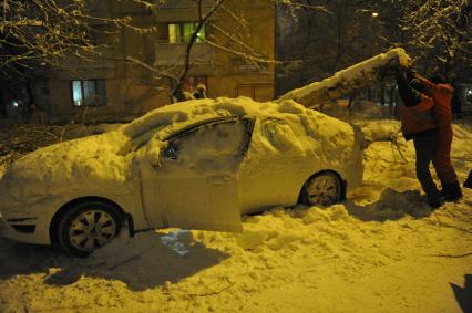 Последствия снегопада. На снимке: упавшее дерево на автомобиле.