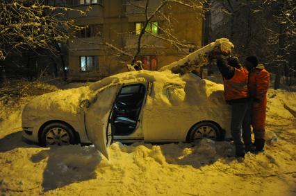 Последствия снегопада. На снимке: упавшее дерево на автомобиле.