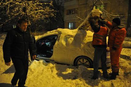 Последствия снегопада. На снимке: упавшее дерево на автомобиле.