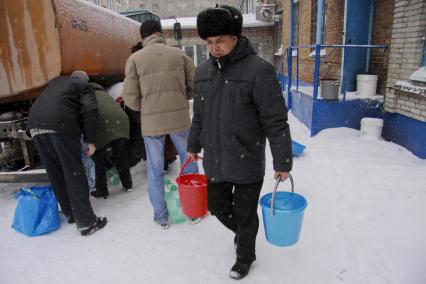 Аварийное отключение воды. На снимке: мужчина с ведрами воды.