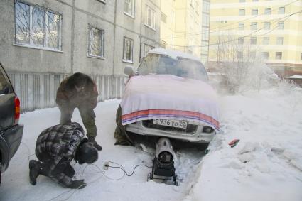 Барнаульские автолюбители прогревают автомобиль с помощью тепловой пушки.