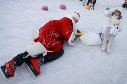 Забег Дедов Морозов на коньках. Дед Мороз упал на катке, на помощь спешит Снегурочка.