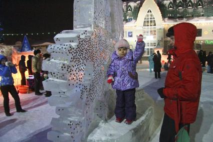 Празднование старого нового года на улицах Барнаула. Жители города закрепляют монетки на ледяных скульптурах на счастье.