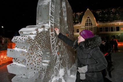 Празднование старого нового года на улицах Барнаула. Жители города закрепляют монетки на ледяных скульптурах на счастье.