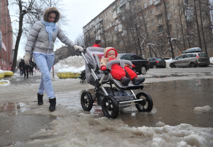 Молодая женщина с ребенком в коляске