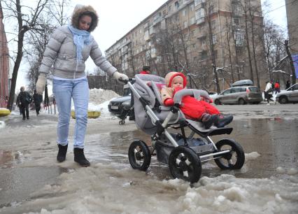 Молодая женщина с ребенком в коляске