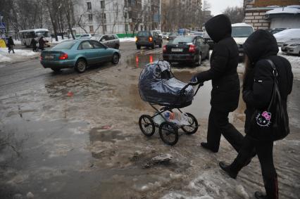 Женщина с коляской переходит дорогу