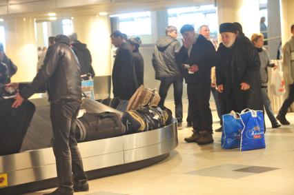 Аэропорт Домодедово. На снимке: пассажиры у ленты багажного транспортера.