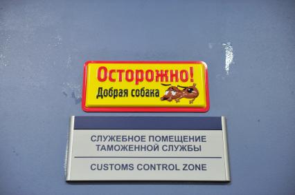 Аэропорт Домодедово. Служебное помещение таможенной службы. На снимке: табличка `Осторожно! Добрая собака`