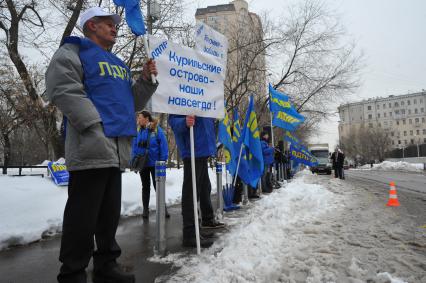 Митинг Московского отделения ЛДПР у посольства Японии. На снимке: участник митинга с плакатом `Курильские острова-наши навсегда!`