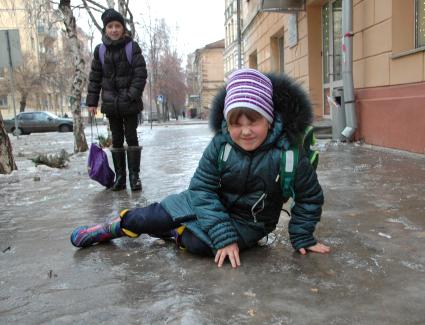 Девочка упала на заледеневшем тротуаре.