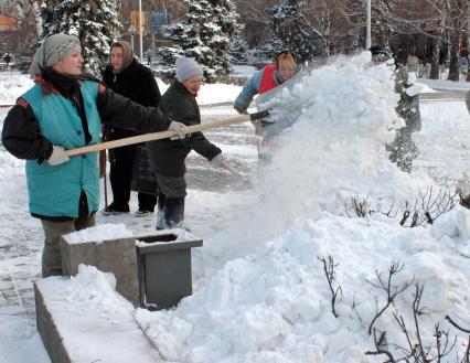 Работа коммунальных служб зимой. Дворники работают лопатами, очищают улицы от снега.