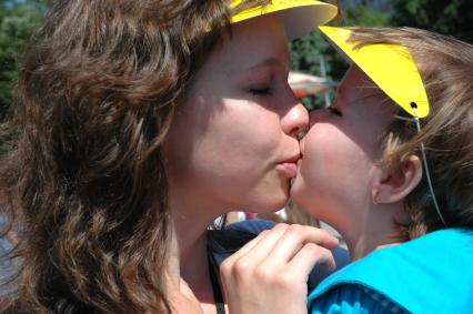 Женщина целует ребенка.