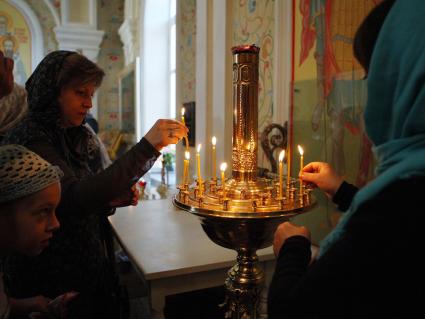 В Ставрополе, в храме Преображения господня прошел молебен детей-инвалидов. На снимке: Люди ставят свечи.